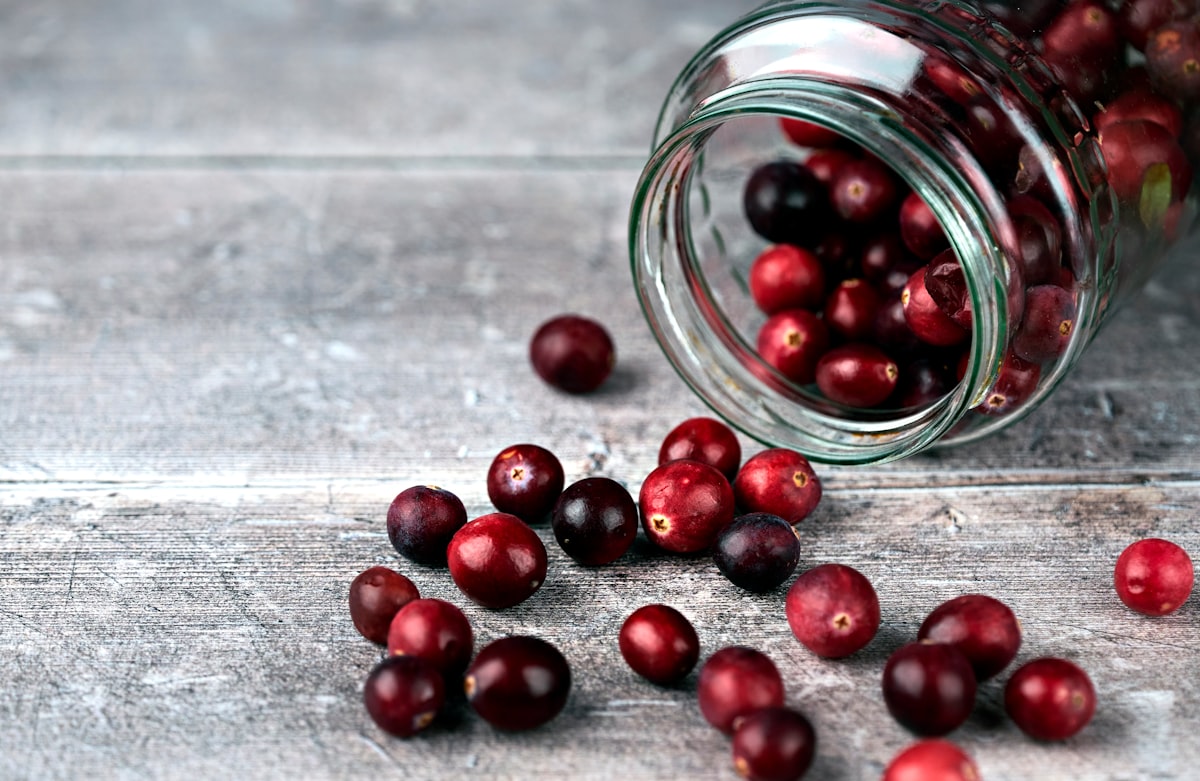 Fresh cranberries in a glass jar for supplement guide