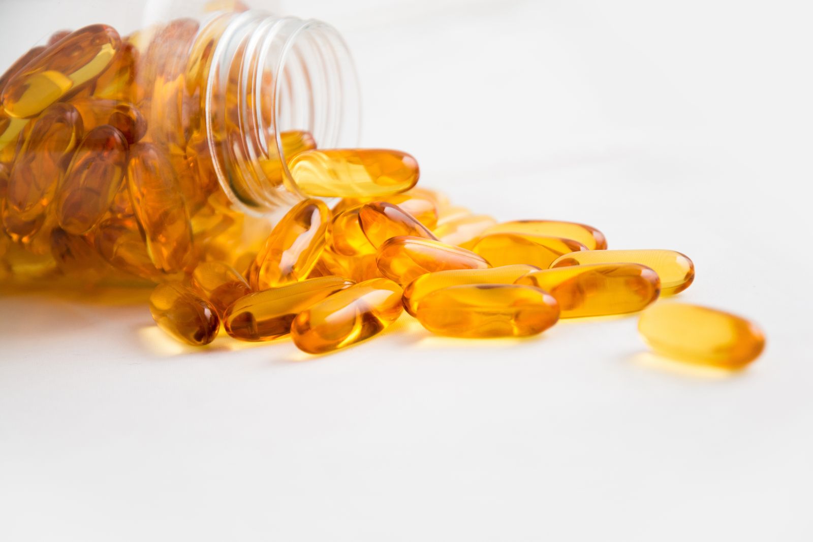 魚油 Omega-3 完整指南 2026 封面:金色魚油膠囊從瓶中倒出散落桌面,呈現 Omega-3 保健意象